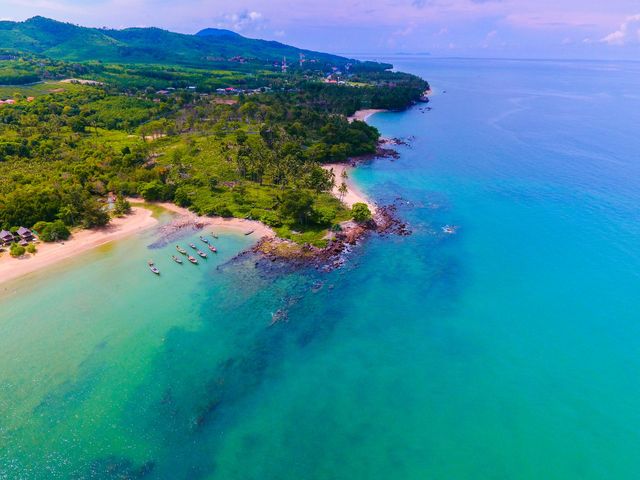 Flygbild över en strand och grön skog på Koh Lanta