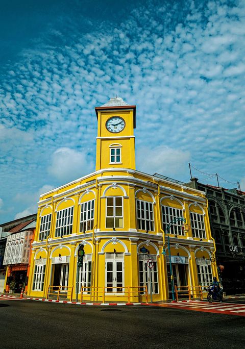 Gult tvåvåningshus med klocktorn i Phuket Old Town